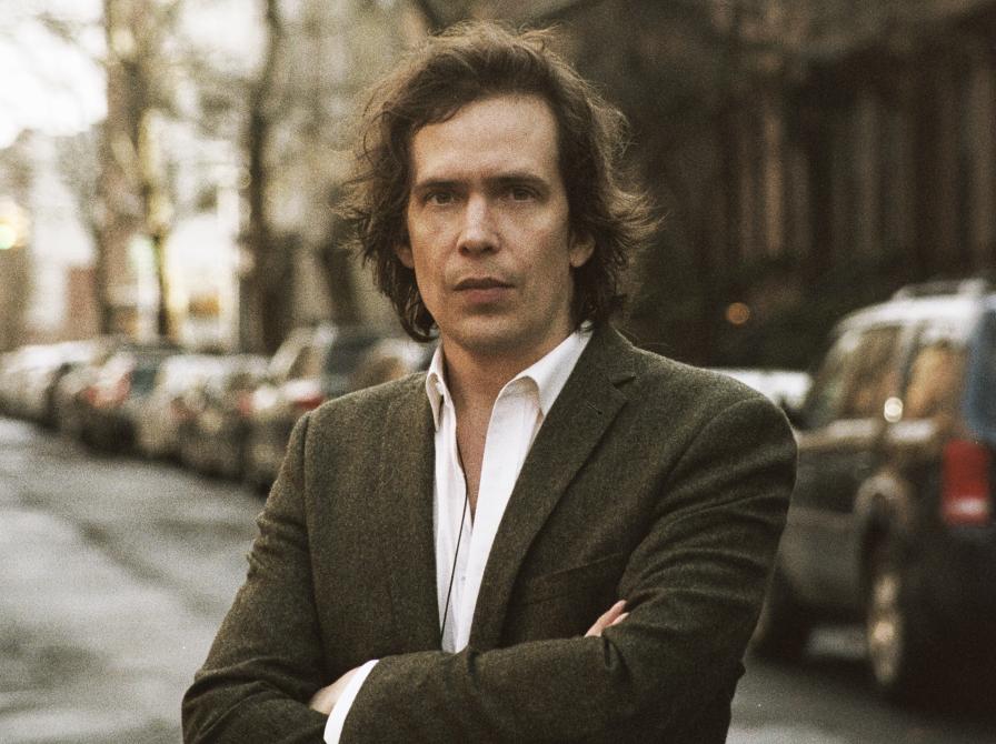 Portrætfoto af Kristian Leth med en Københavns gade i baggrunden